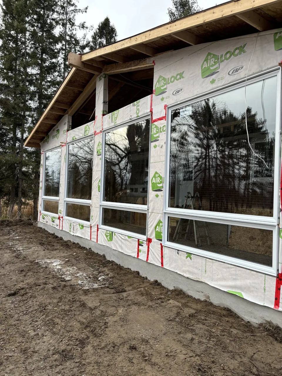 Angled view of large white-framed windows on a building under construction.