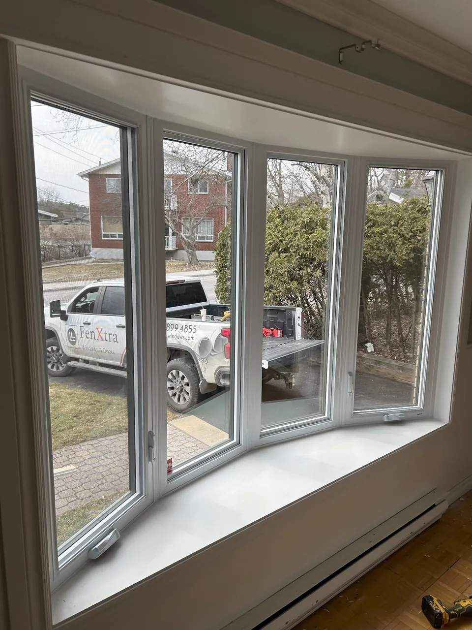 Interior view of a white-framed bay window with a deep sill.